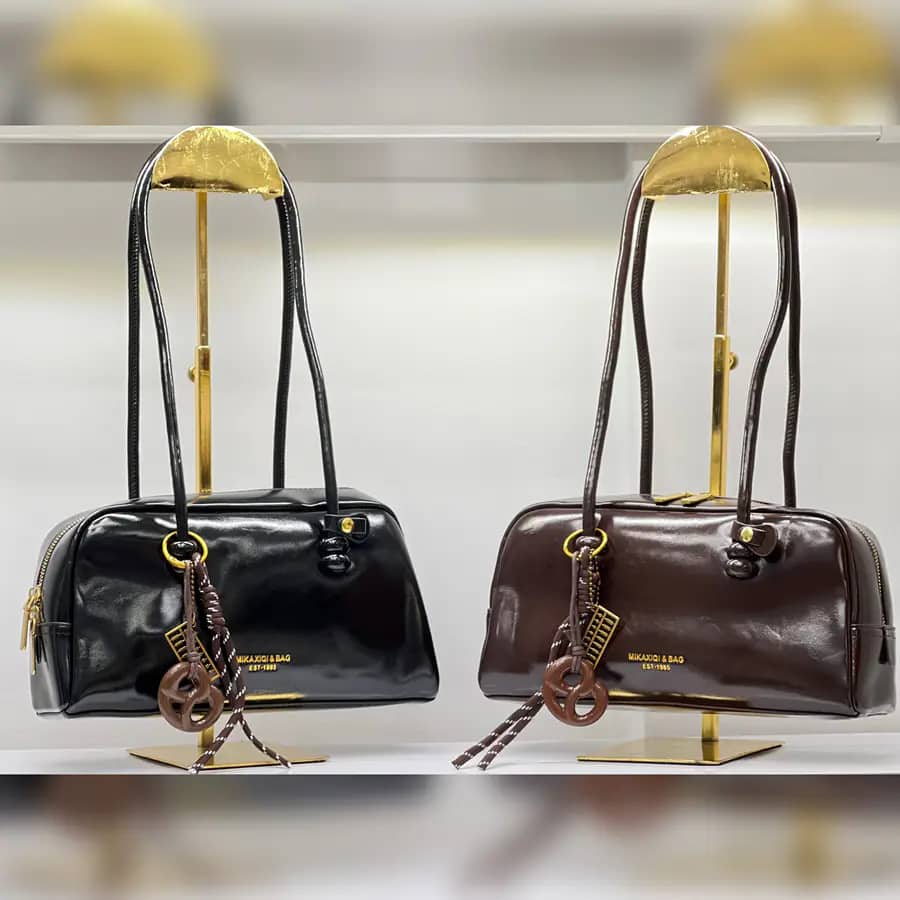 کیف دوشی استوانه‌ای چرم براق با آویز حلقه و بند چرمی